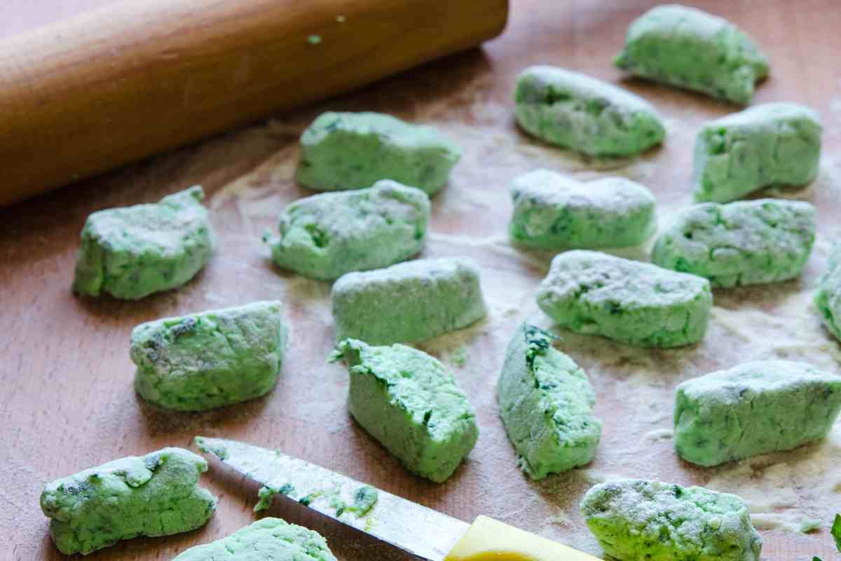 gnocchi alla rucola sulla spianatoia con vicino un mattarello