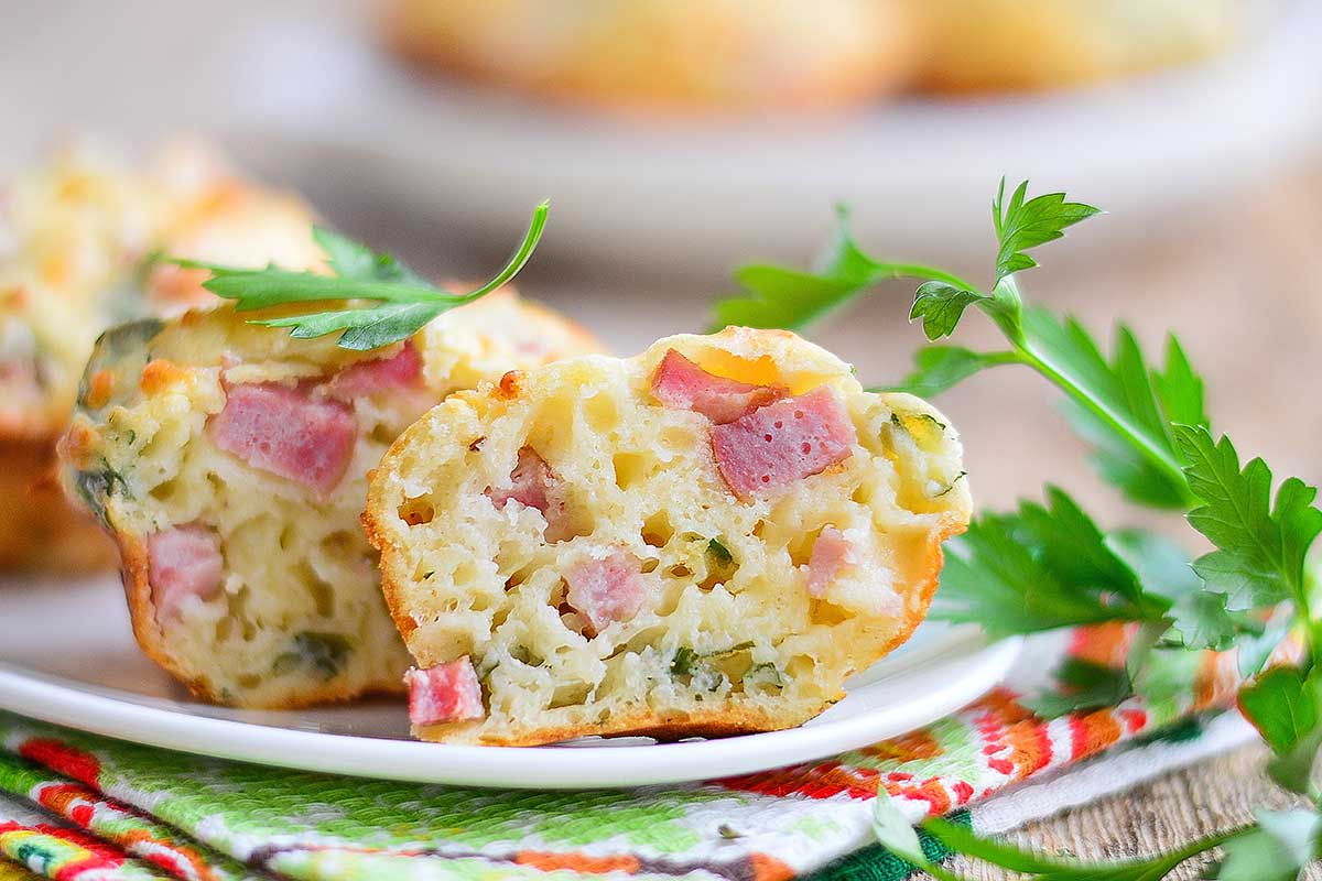 Piatto con muffin aperto a metà con prosciutto cotto e formaggio