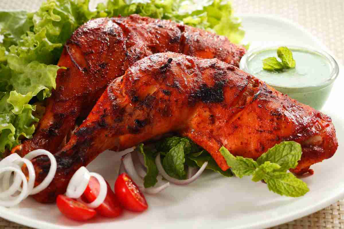 Due cosce di pollo tandoori in un piatto
