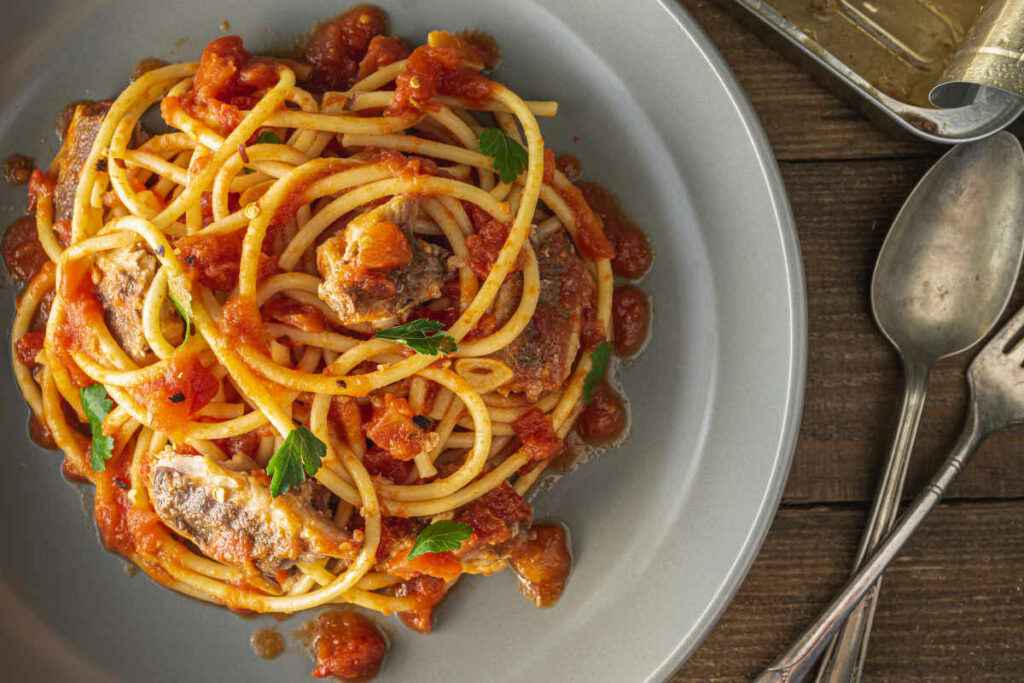 piatto di bucatini con il sugo di sarde e pomodoro