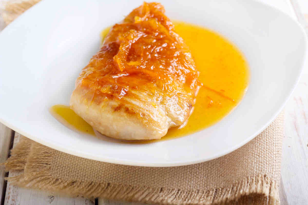 piatto bianco con filetto di petto di pollo all'arancia