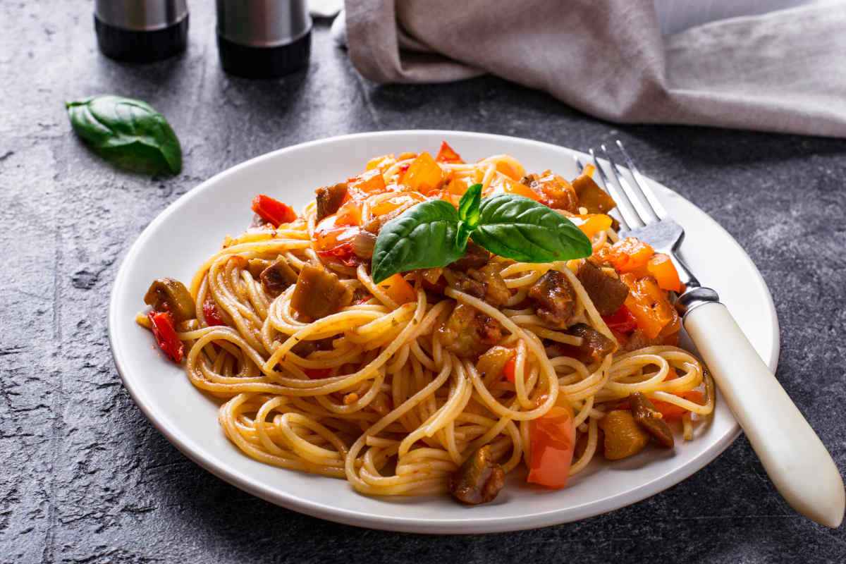 piatto di spaghetti con sugo di melanzane e peperoni