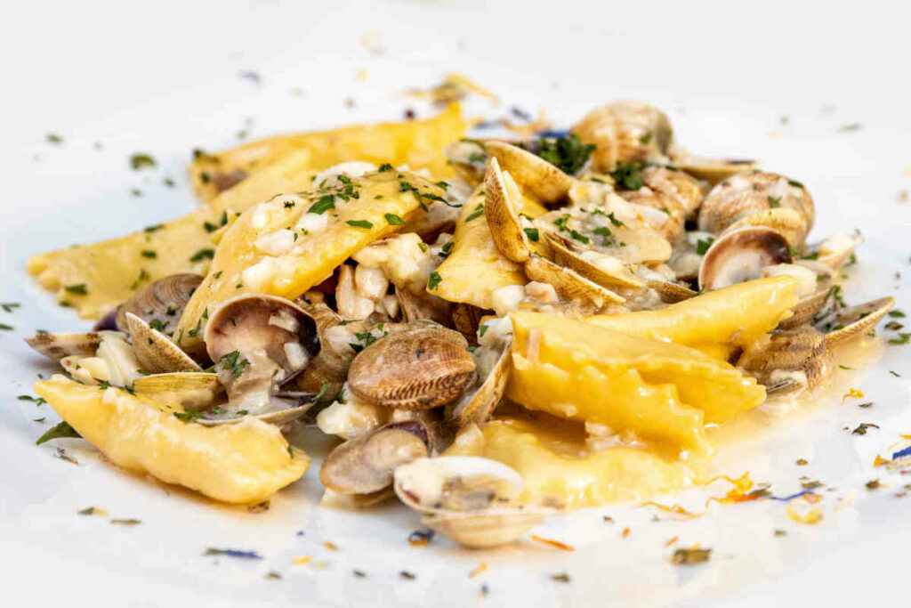 piatto di ravioli di cernia con scampi e vongole