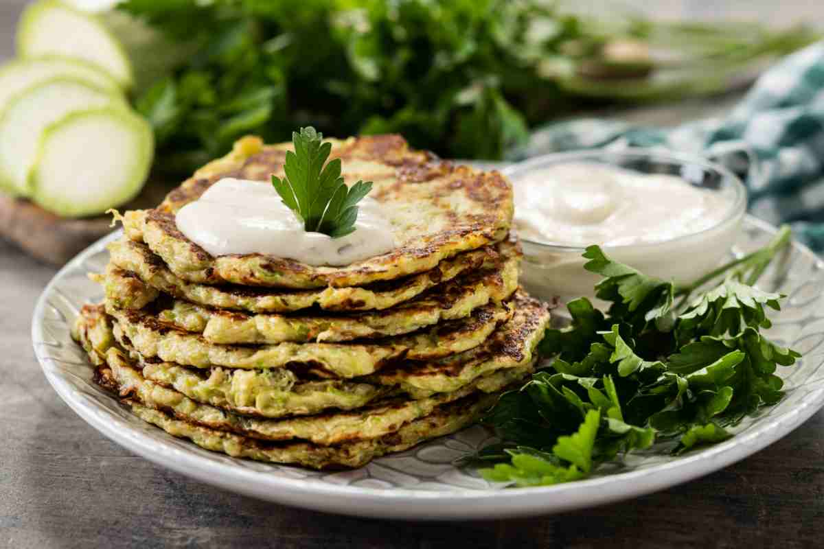 Frittelle di zucchine con salsa di yogurt in un piatto