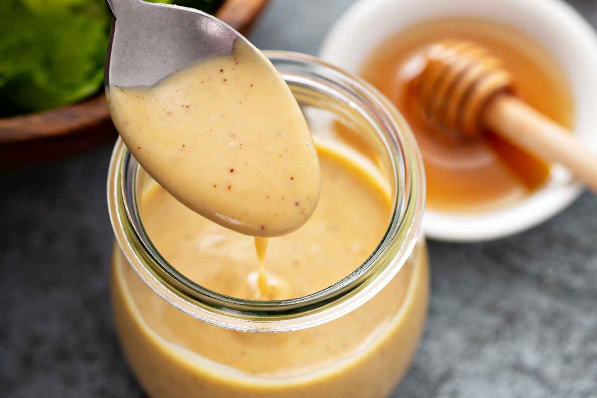 salsa delle api in un barattolo di vetro con un cucchiaio