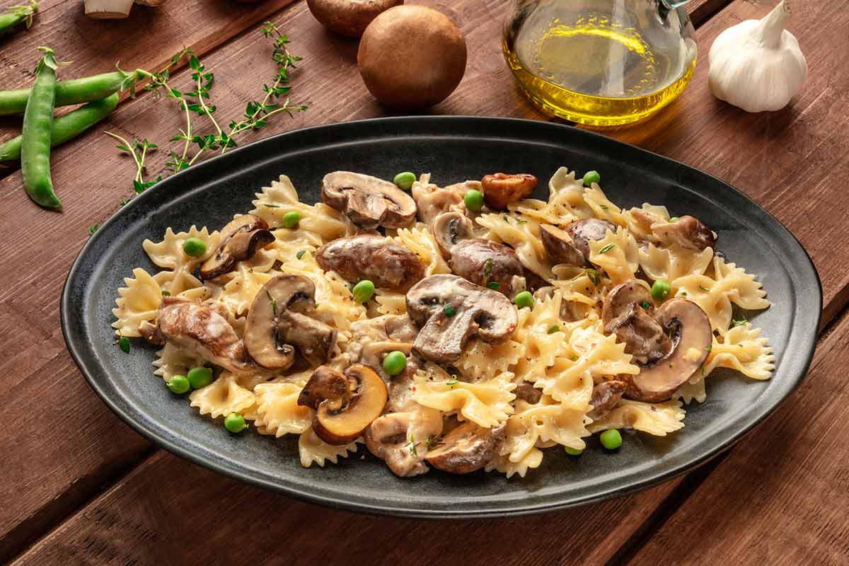 Pasta con funghi, piselli e speck