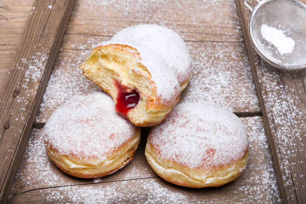 tavola di legno col krapfen alla marmellata coperti di zucchero a velo