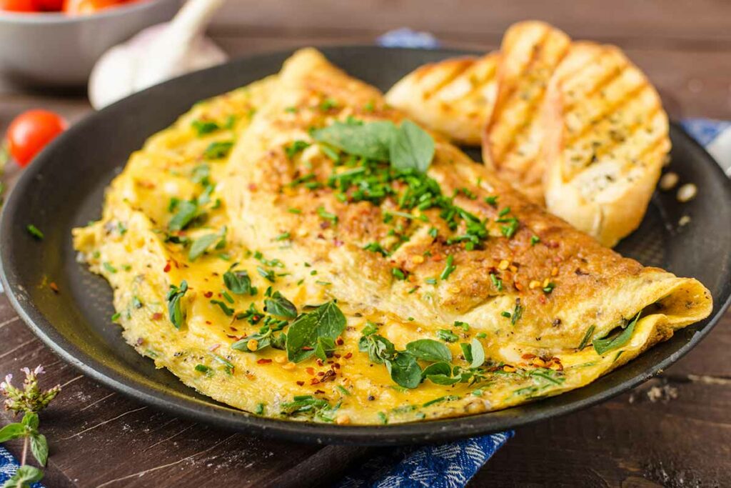 Piatto scuro con un'omelette di uova realizzata secondo la ricetta tradizionale francese