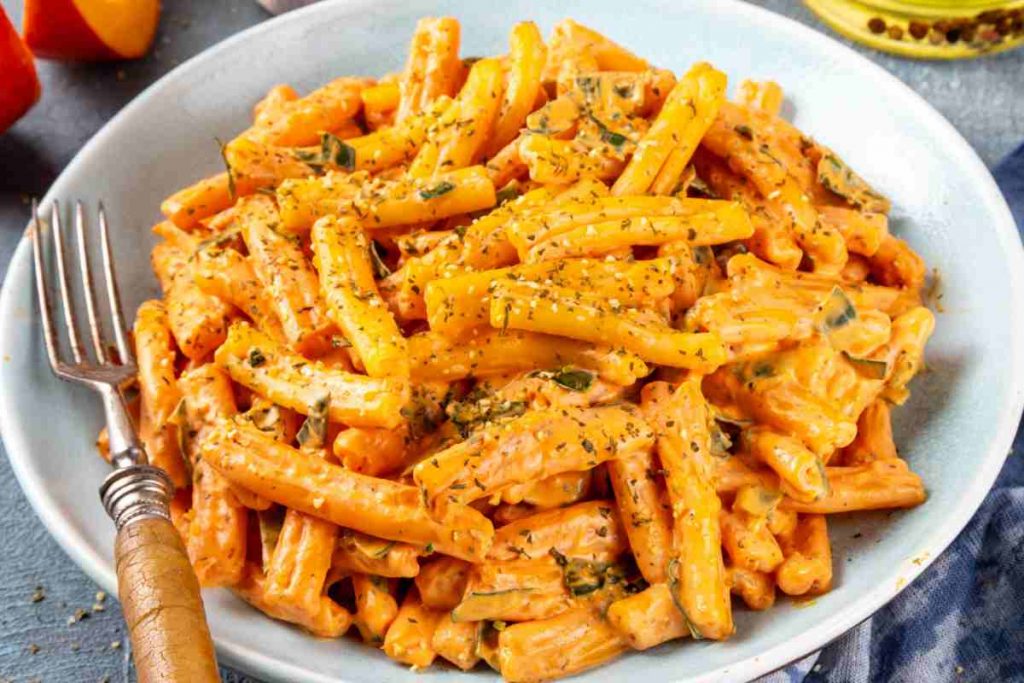 un piatto di pasta con la zucca con dentro una forchetta