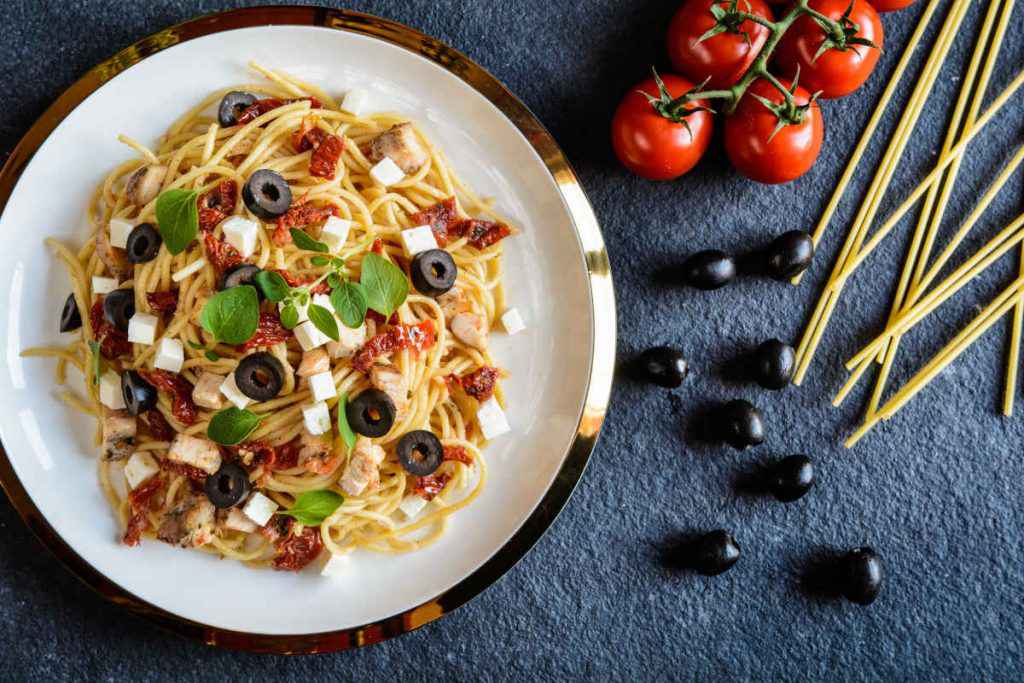 piatto di pasta con pomodori secchi olive e feta