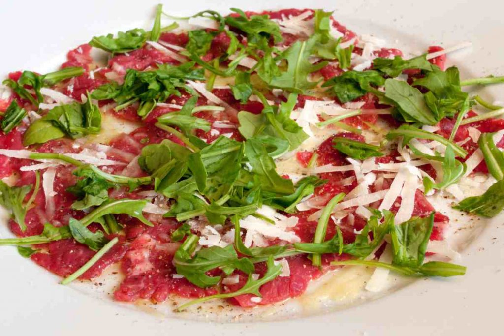 piatto con carpaccio di manzo con grana e rucola