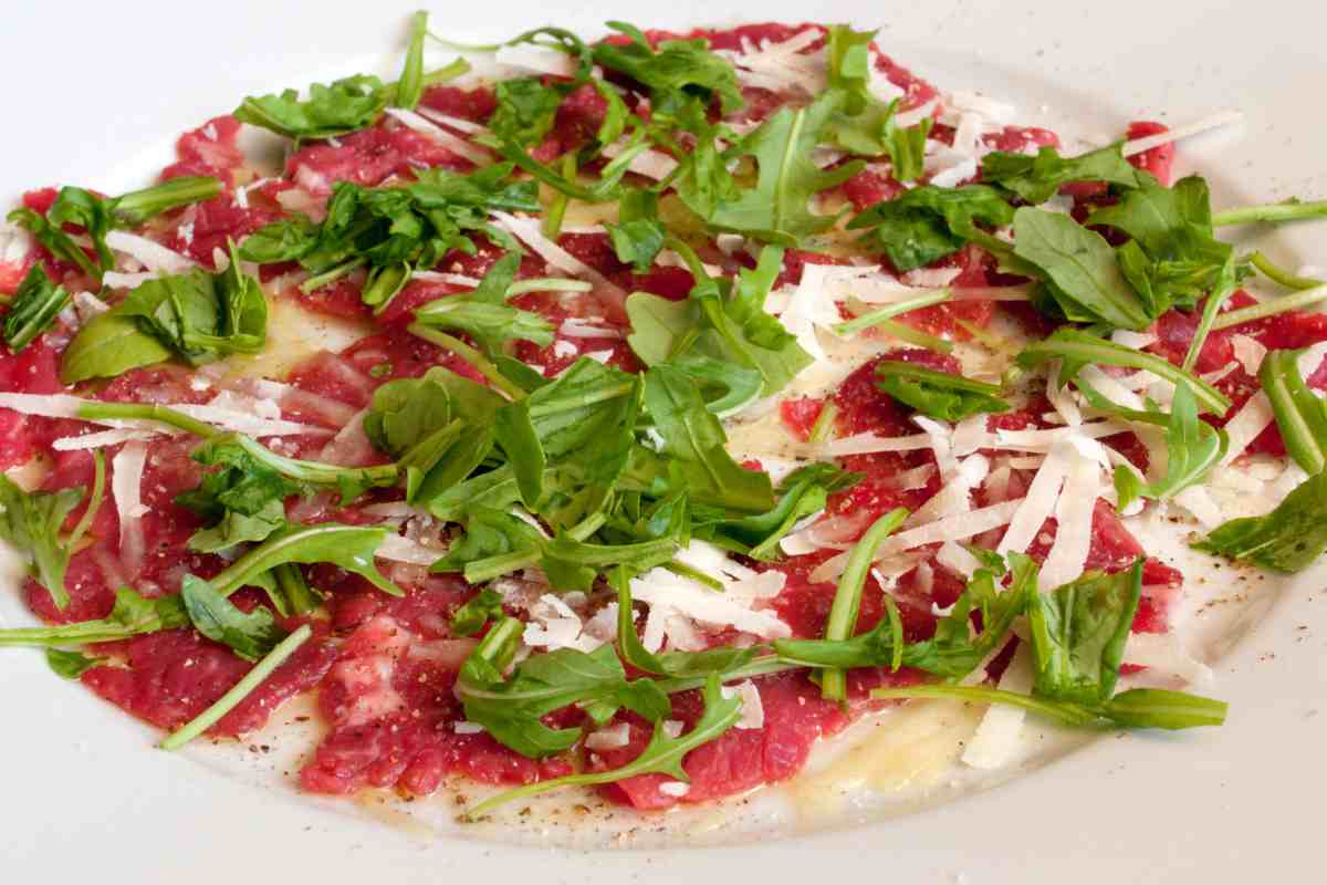 piatto con carpaccio di manzo con grana e rucola