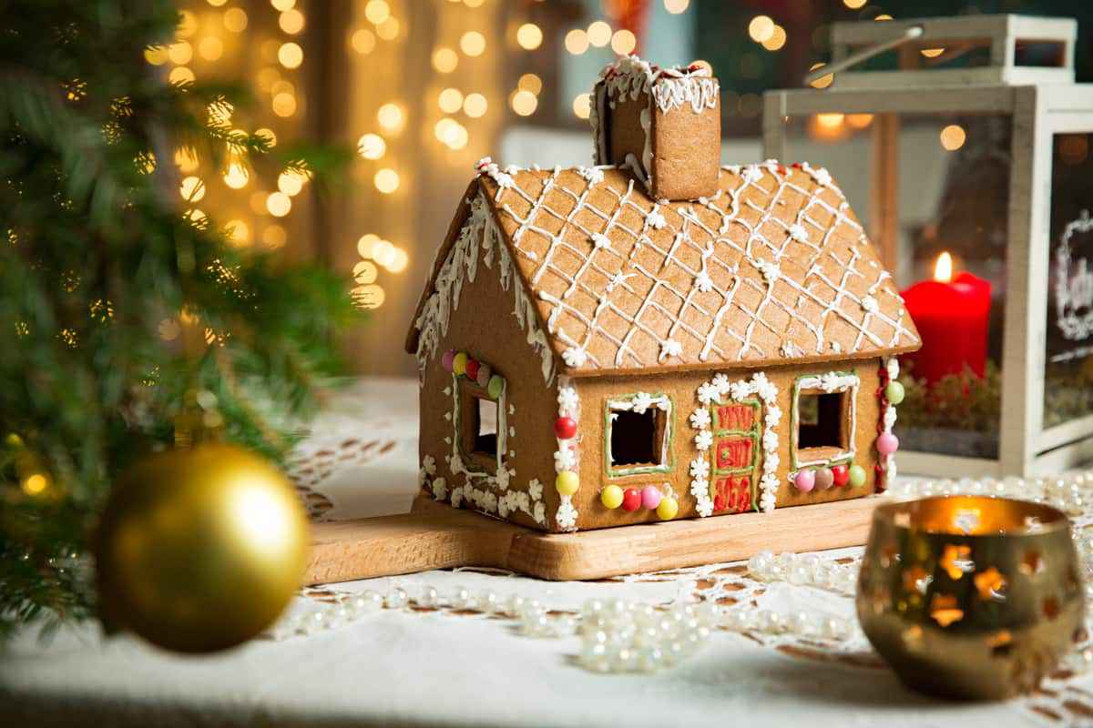 Casetta di biscotto decorata con glassa e caramelle colorate dolce di Natale