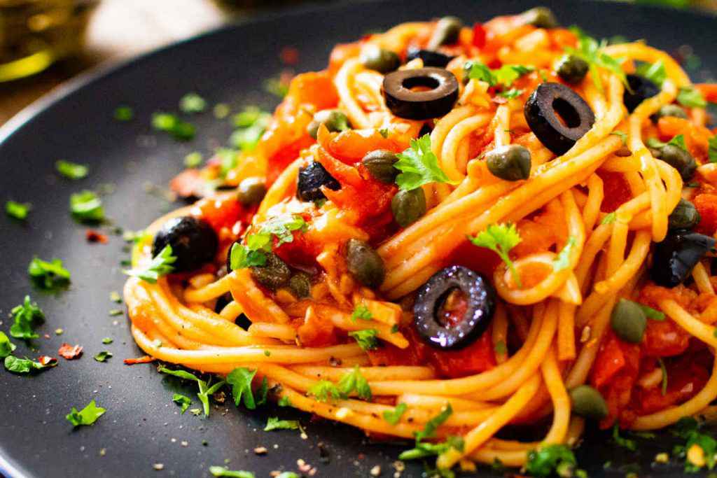 piatto di pasta con spaghetti alla puttanesca per il pranzo di ferragosto