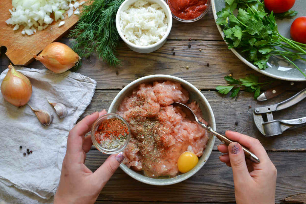 donna prepara la ricetta delle polpette di pollo partendo dall'impasto