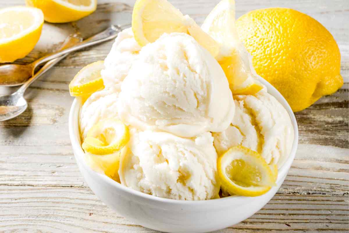 coppetta con gelato al limone bimby guarnito con fette di limone su un tavolo di legno