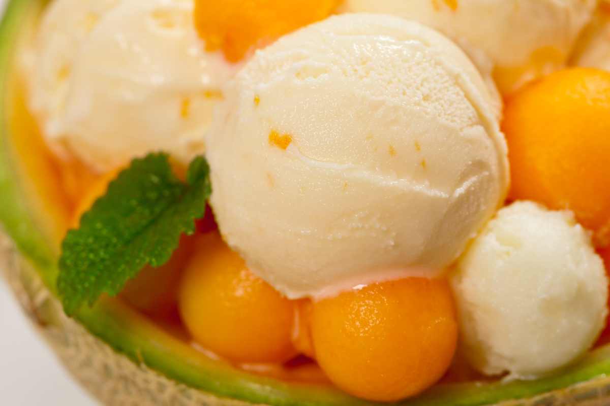 palline di gelato al melone in un melone scavato con decorazione di palline di melone