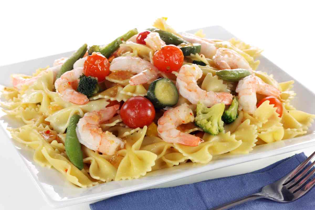 Piatto di insalata di pasta con gamberetti, zucchine, fagiolini, pomodorini
