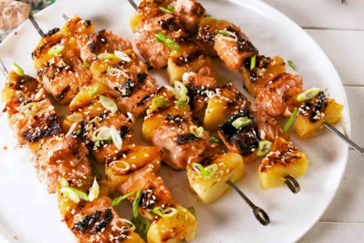 piatto con spiedini di salmone e ananas visti dall'alto