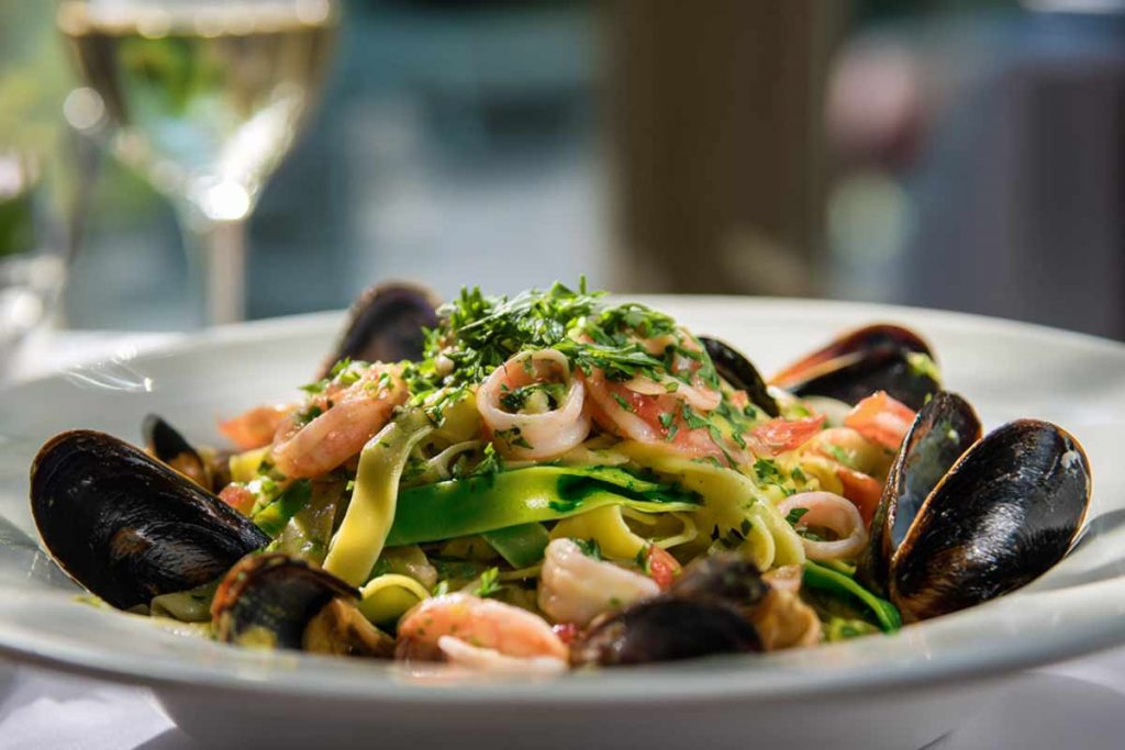 Tagliatelle paglia e fieno con il pesce in un piatto