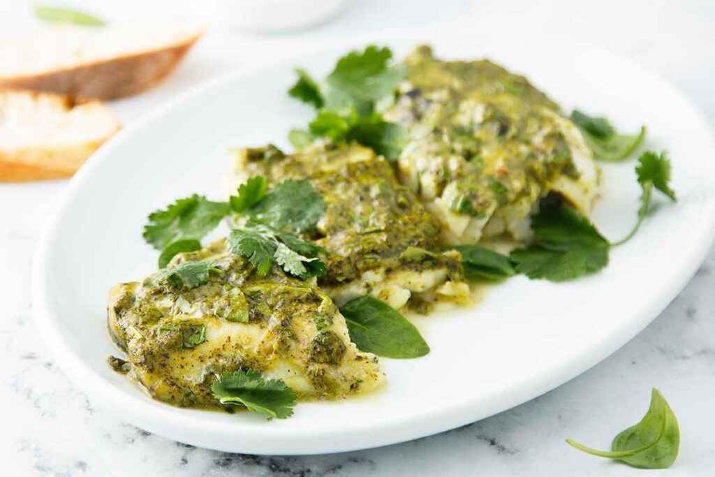 Piatto con tre tranci di pesce coda di rospo con pesto di basilico