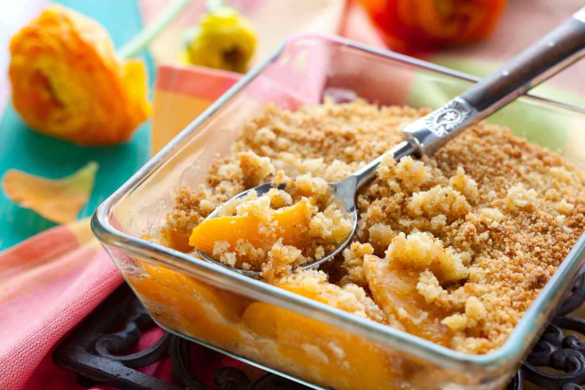 teglia di vetro con crumble alle pesche