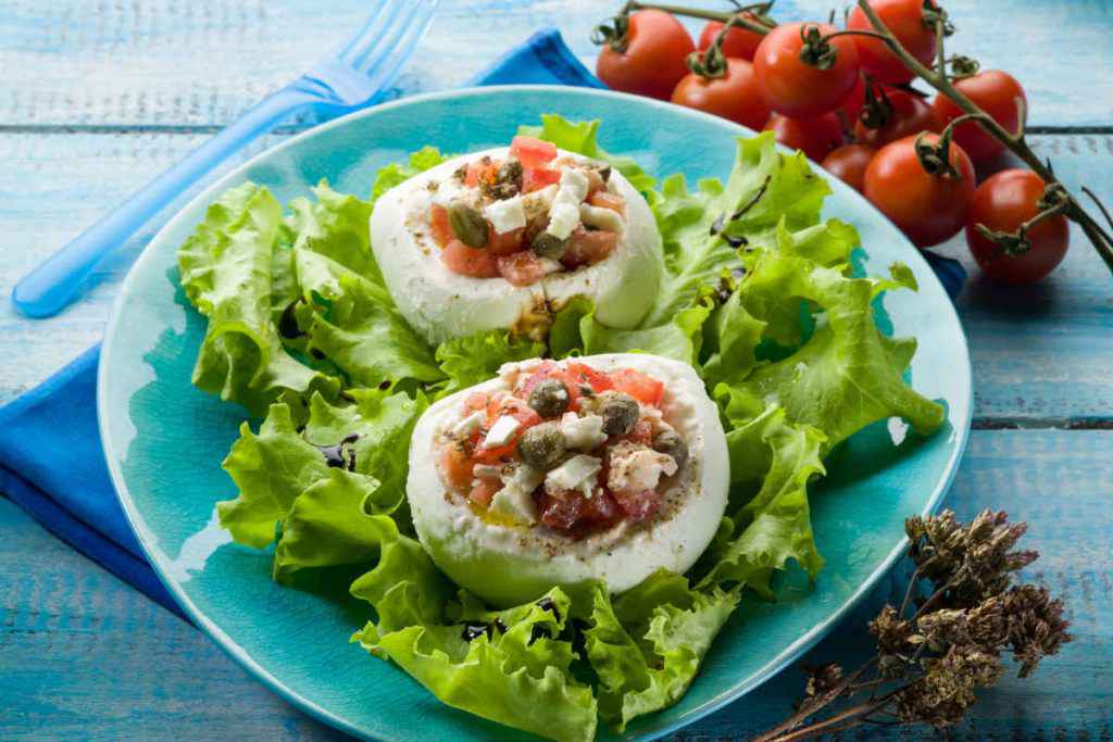 piatto con mozzarella ripiena di verdure su letto di insalata per antipasti senza cottura