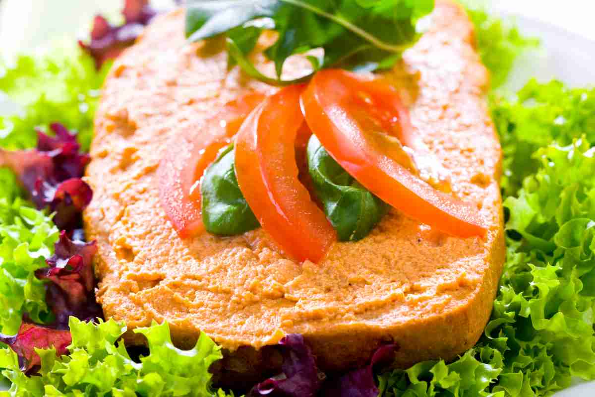 Mousse di tonno spalmata su una fetta di pane con pomodoro