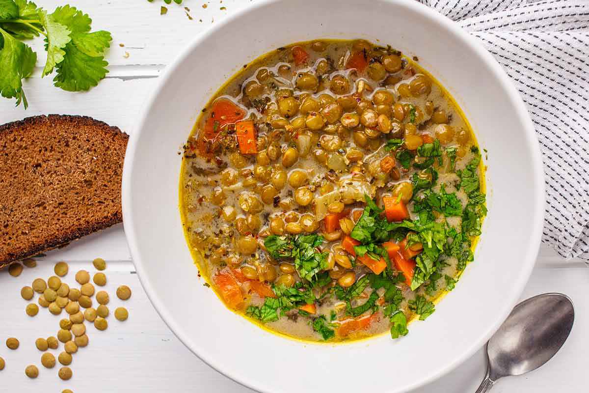 Piatto bianco con all'interno una zuppa di farro e lenticchie