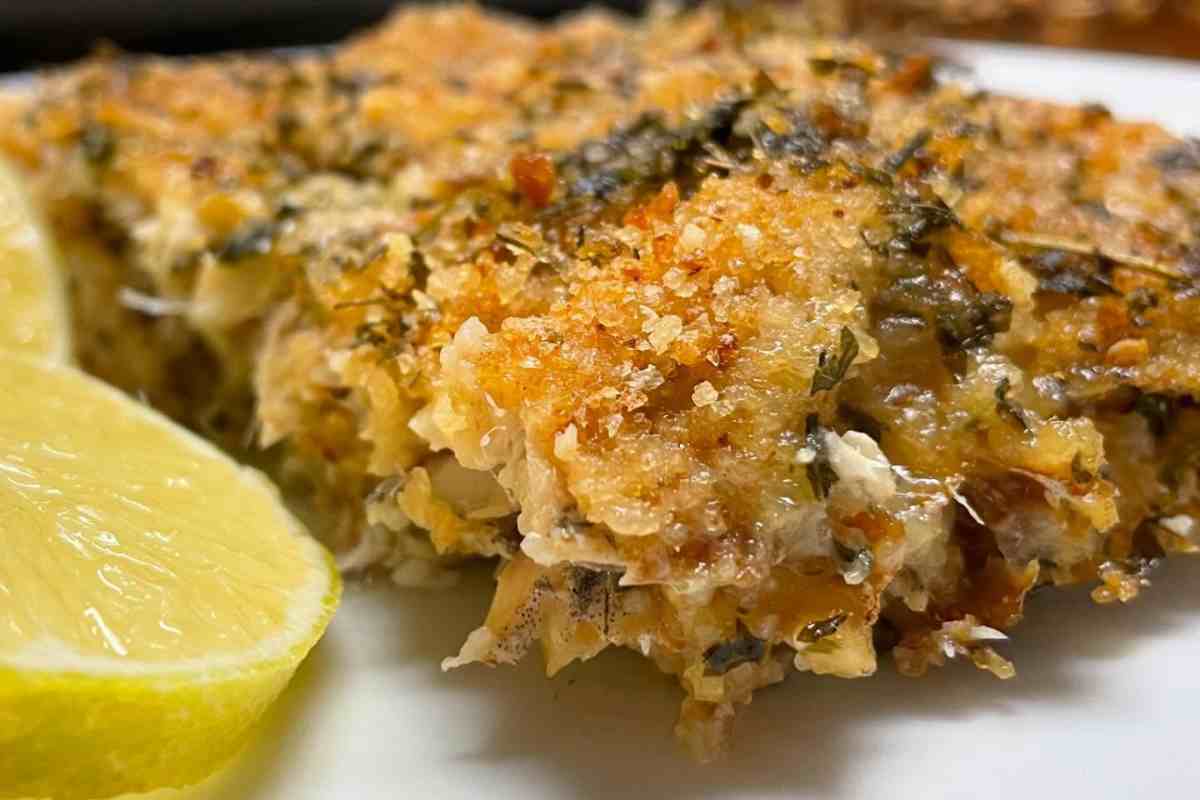 tortino di alici alla siciliana in un piatto con un mezzo limone vicino