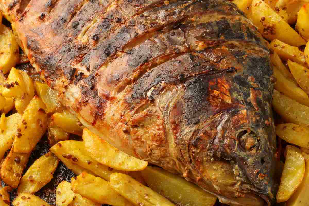 Carpa al forno su un letto di patate arrostite
