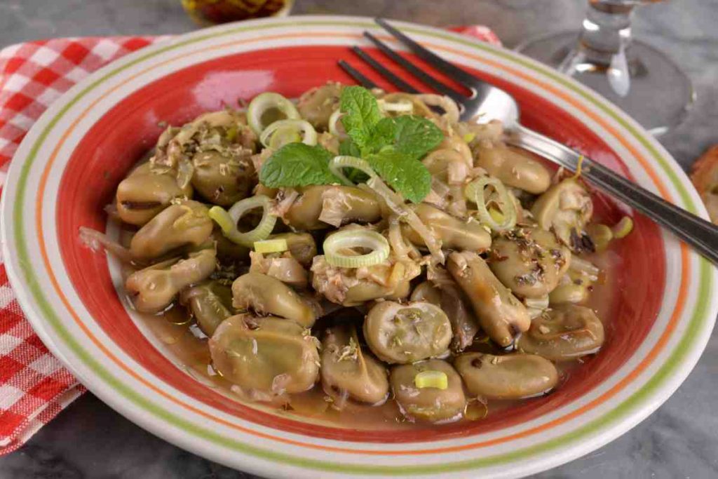 Fave a coniglio con cipollotti in un piatto