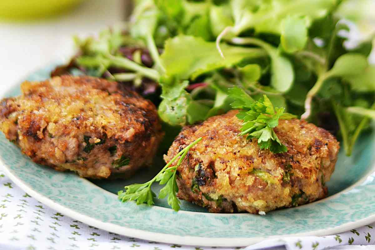 Polpette di patate e zucchine con contorno di insalata in un piatto