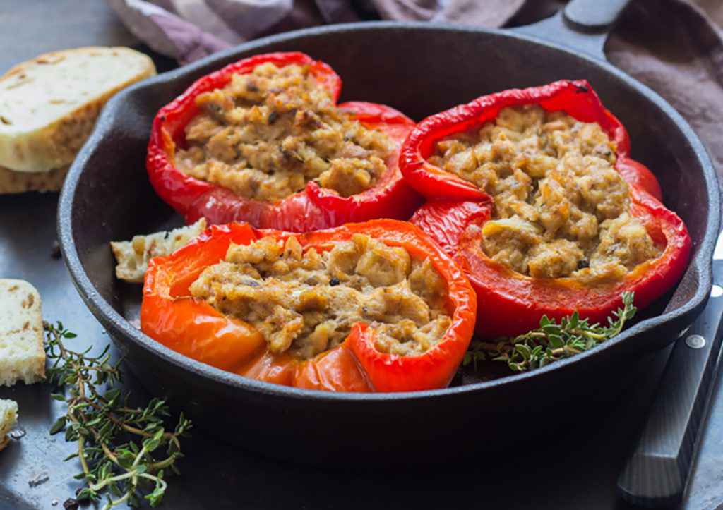 Peperoni ripieni di tonno all'interno di un piatto nero decorati con timo