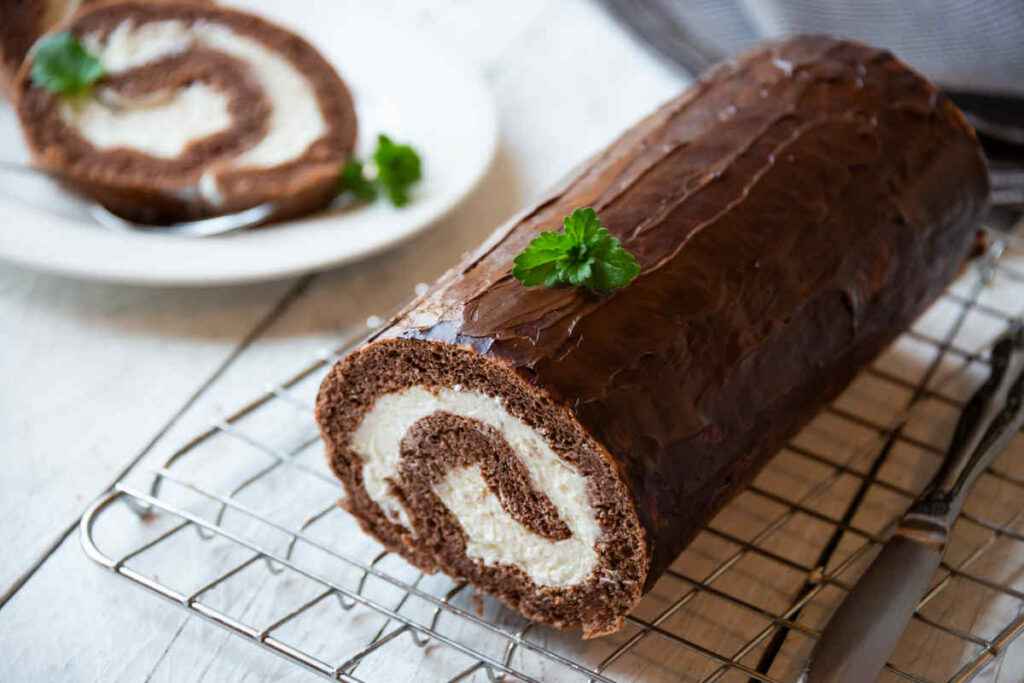 dolce rotolo alla panna ricoperto di cioccolato