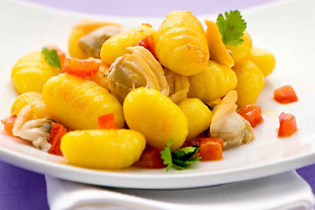 Piatto di gnocchi con vongole e pomodorini freschi