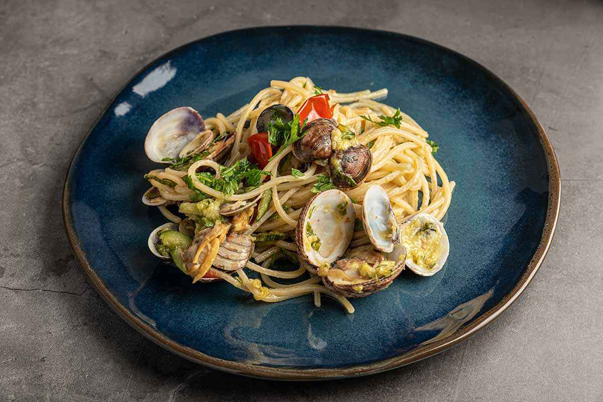 Piatto di spaghetti con le vongole e le zucchine