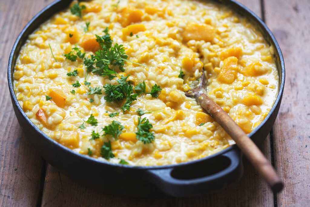 Padella con del risotto alla zucca mantecato con formaggio e prezzemolo