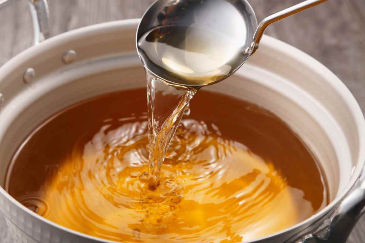 una pentola con il brodo di carne preso con un mestolo