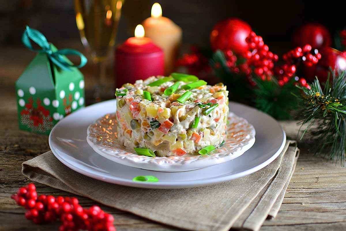 Piatto di insalata russa con decorazioni natalizie attorno