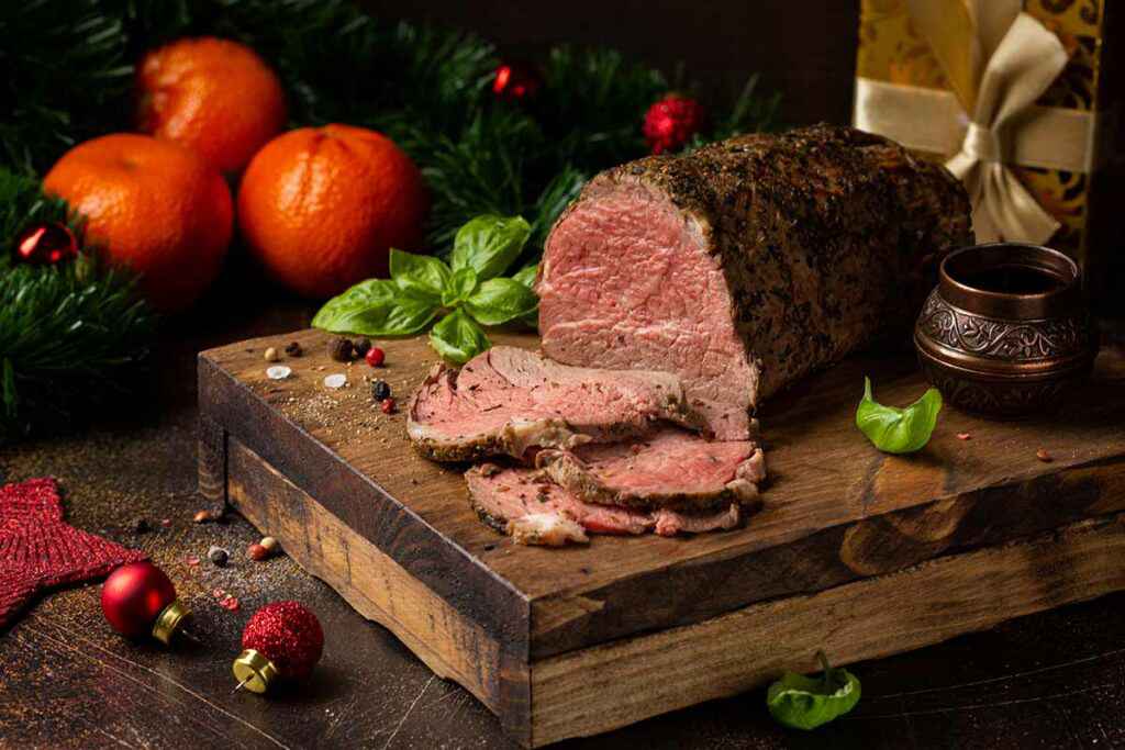 Tagliere di legno con sopra del roast beef al sangue appena affettato