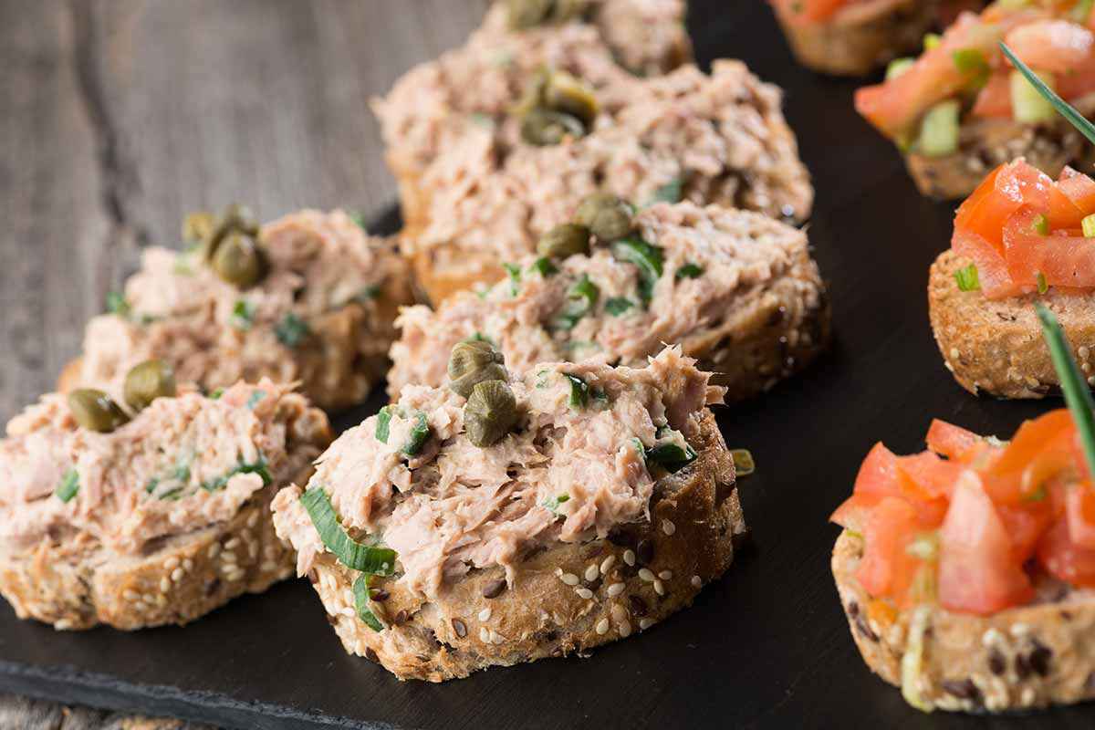 Tartine con tonno capperi e acciughe su di un vassoio