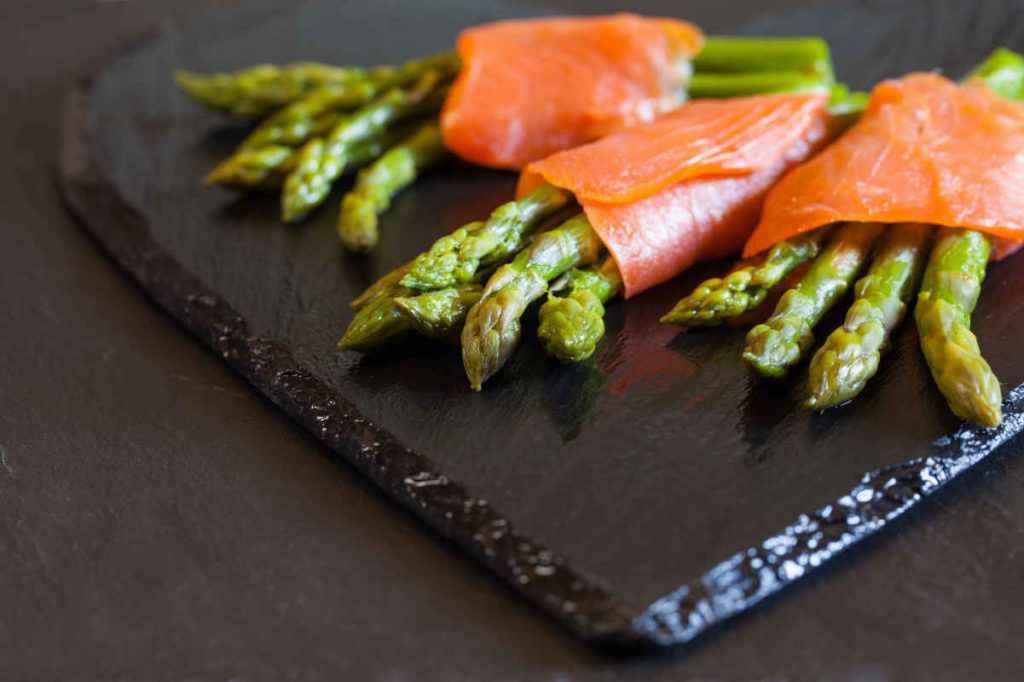 tagliere di ardesia con salmone affumicato e asparagi