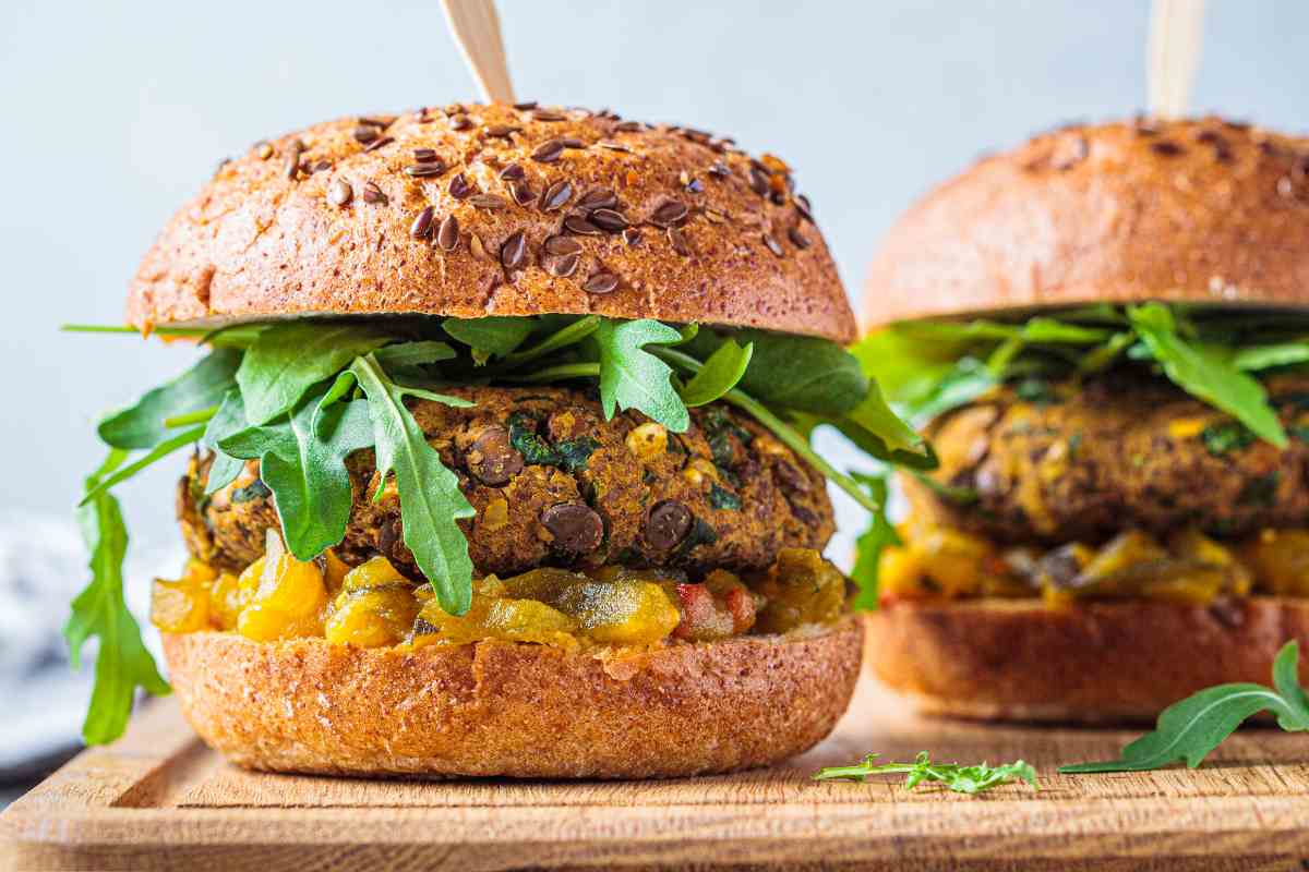Panini con hamburger di lenticchie su un tagliere di legno