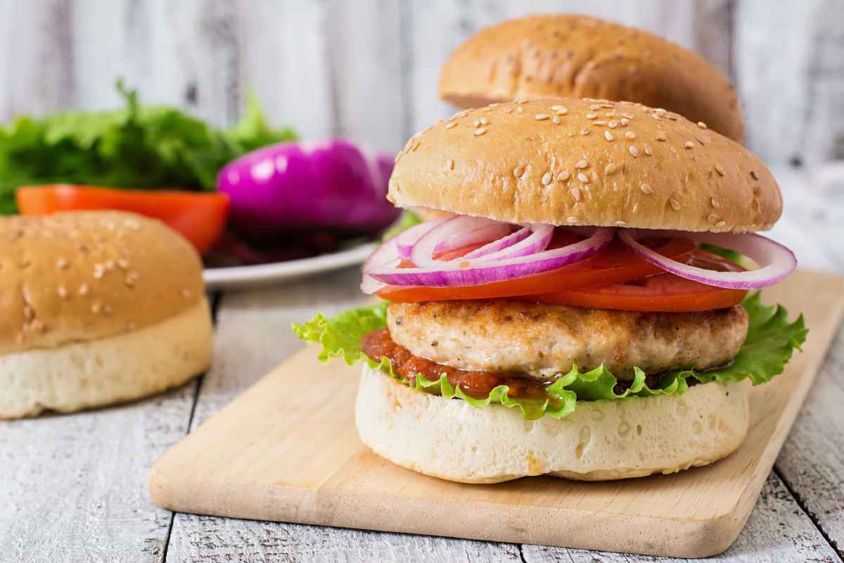 hamburger di pollo nel panino con pomodoro e cipolla