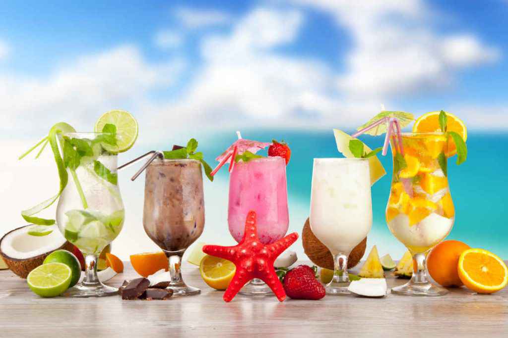 vari tipi di cocktail estivi alcolici e analcolici in bicchieri dalle forme diverse