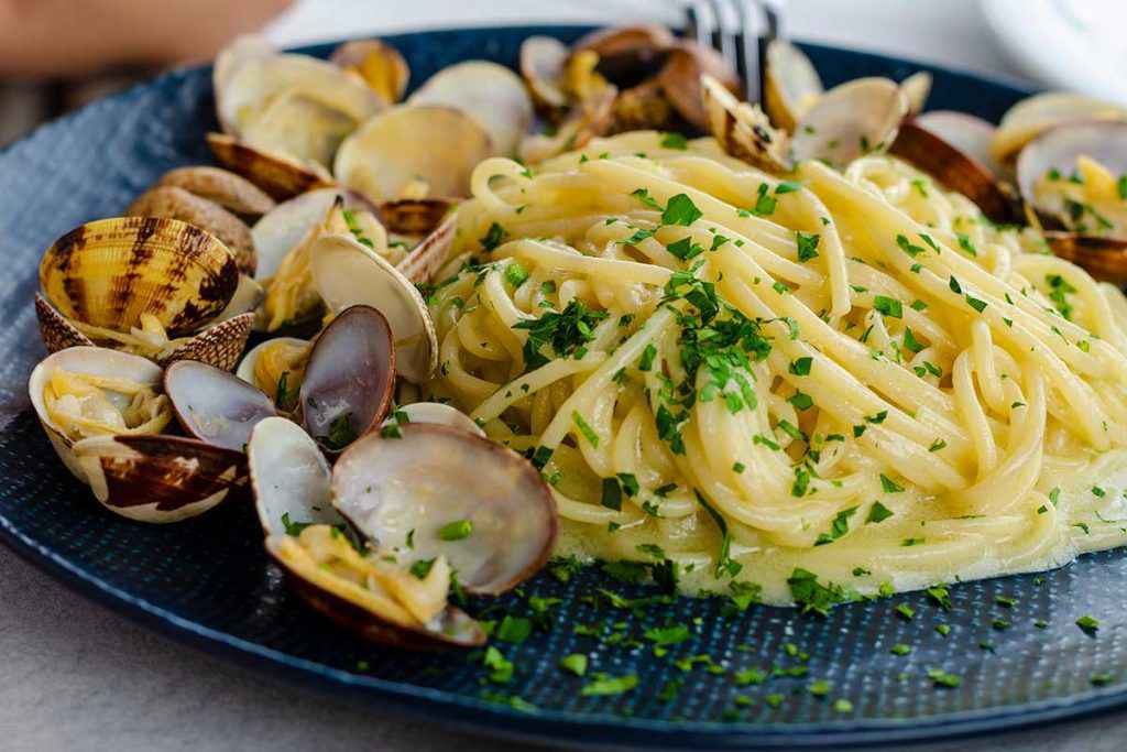 Piatto di spaghetti con vongole fresche e prezzemolo tritato