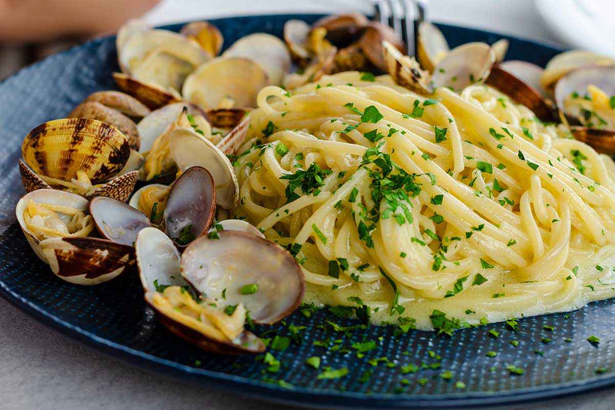 Piatto di spaghetti con vongole fresche e prezzemolo tritato