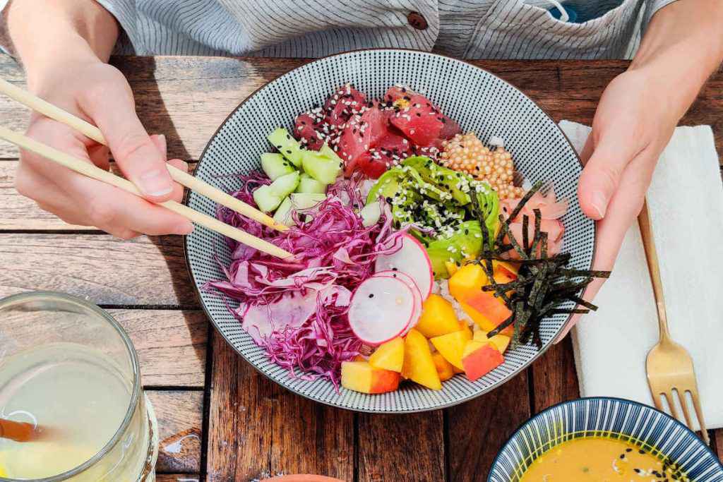 uomo mangia con le bacchette la poke bowl