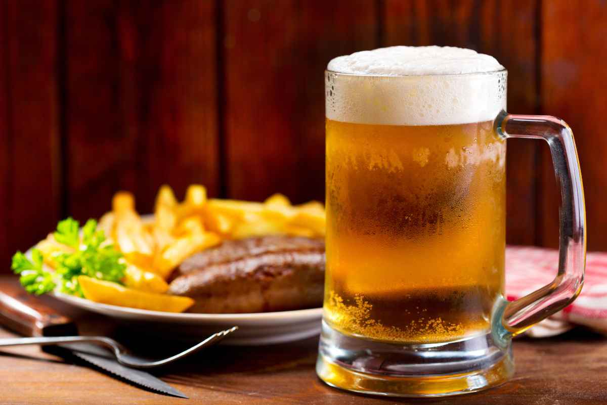 ricette con la birra: un boccale vicino a un piatto di carne